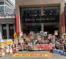 A group of protestors gathers outside of a Wells Fargo location demanding the bank stop investing in fossil fuel projects such as Line 3.